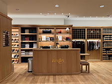 Intérieur de boutique Bexley avec comptoir en bois, pulls, chaussures et accessoires