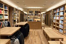 Vue centrale de la boutique Bexley à Marseille avec mobilier en bois, cabines d’essayage et rayons organisés.