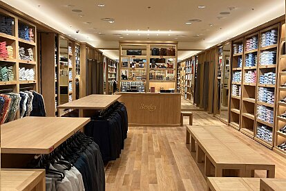 Vue centrale de la boutique Bexley à Marseille avec mobilier en bois, cabines d’essayage et rayons organisés.