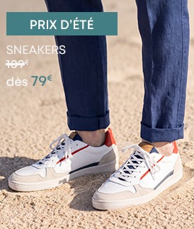 Sneakers homme blanches en cuir avec détails bleu marine et orange, portées avec un pantalon en lin bleu
