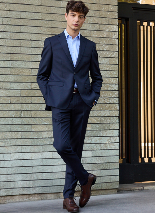 Homme portant un costume bleu marine élégant, style formel urbain.