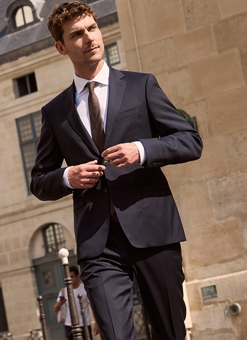 Homme portant un costume bleu marine avec cravate