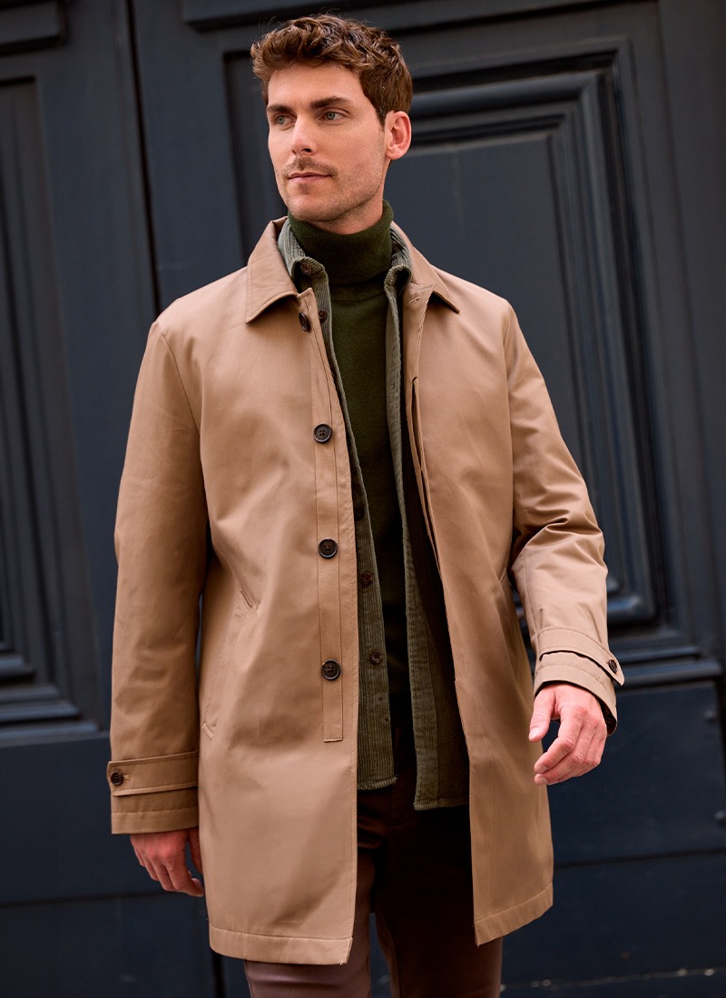Homme portant un trench beige sur une veste en velours côtelé kaki